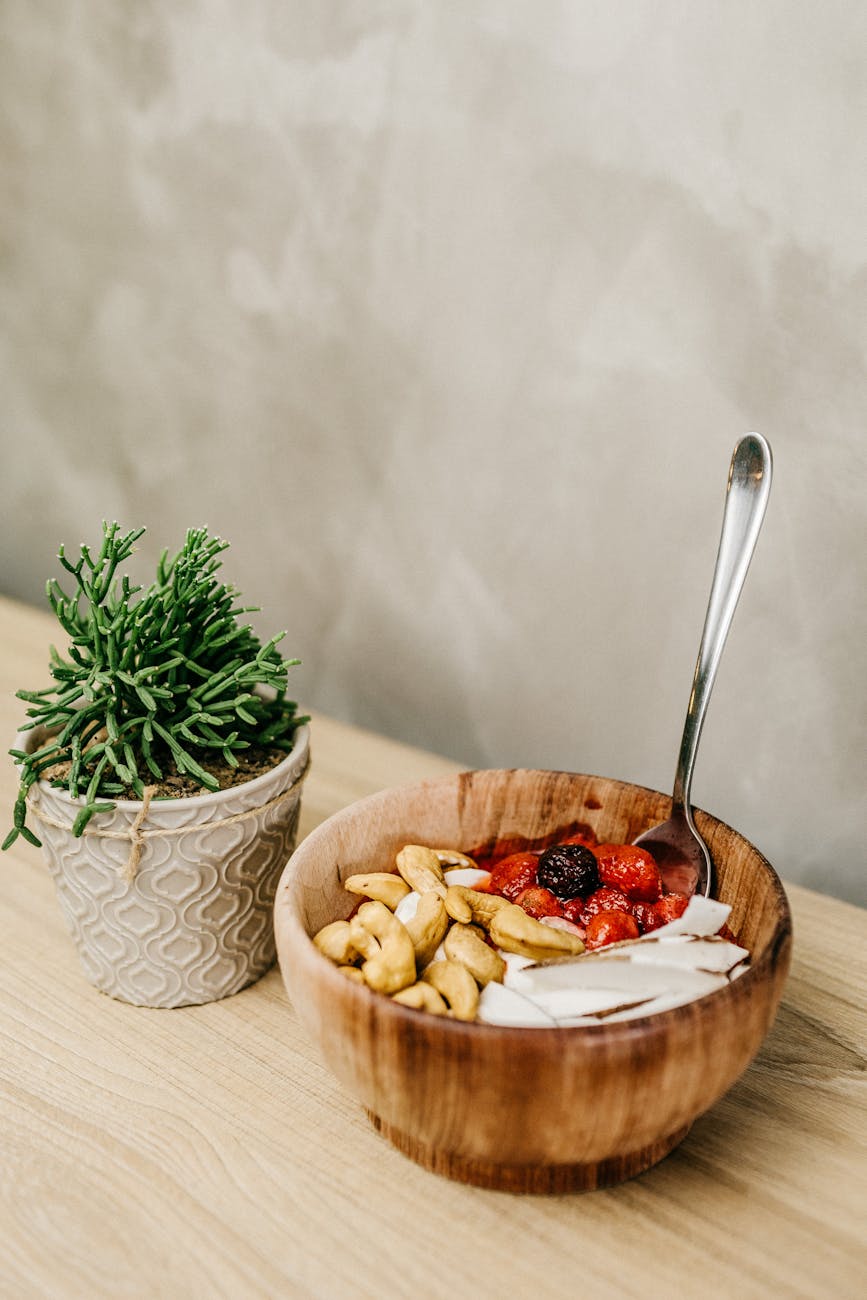 sliced berries and cashews in wooden bowl