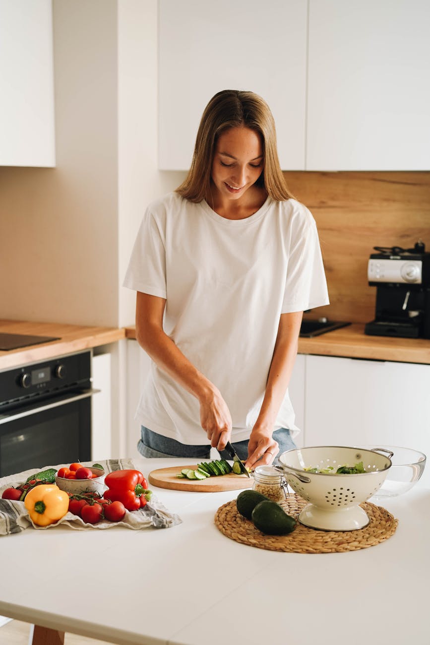 a woman cutting a cucumber